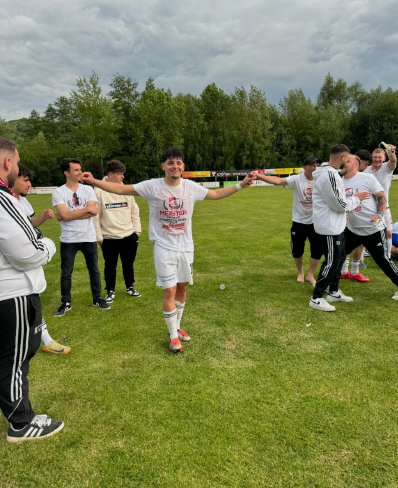 Fußballspieler des SV Bosporus Coburg feiern den Meistertitel 2025 auf dem Spielfeld.